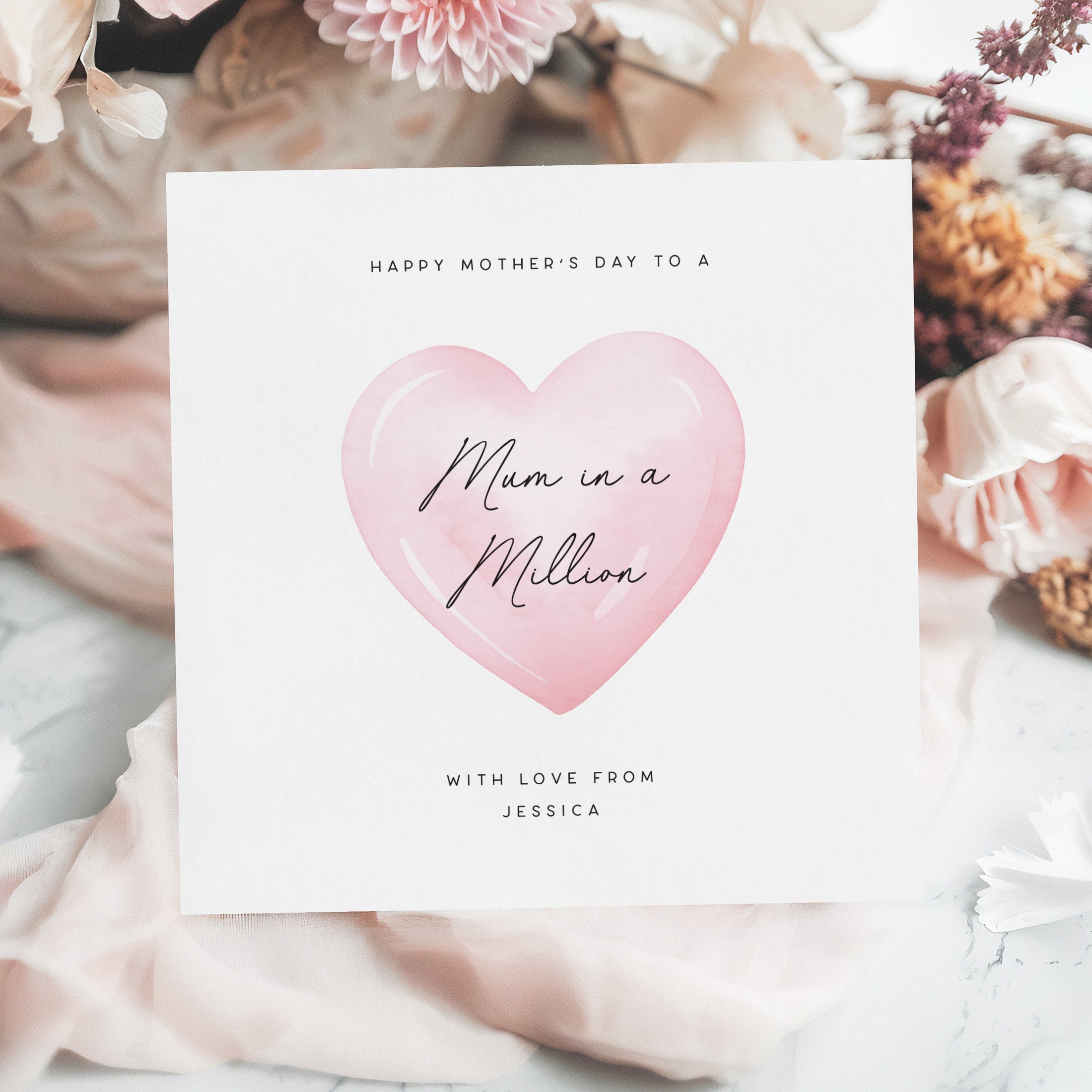 Greeting card with pink heart and 'Mum in a Million' text on a floral background