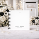 Personalized wedding guestbook with 'Laura & Benjamin' on a decorative background with flowers.