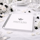 Personalised Guest Book on a wedding breakfast table with white and black flowers