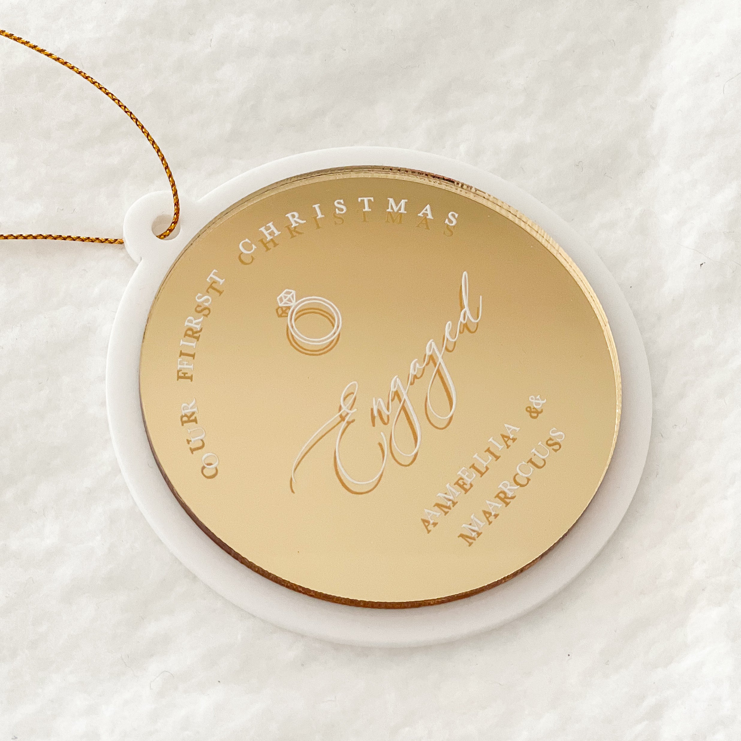 Gloss white acrylic bauble with gold mirror acrylic top that is UV printed in white in with the phrase "our first christmas engaged"