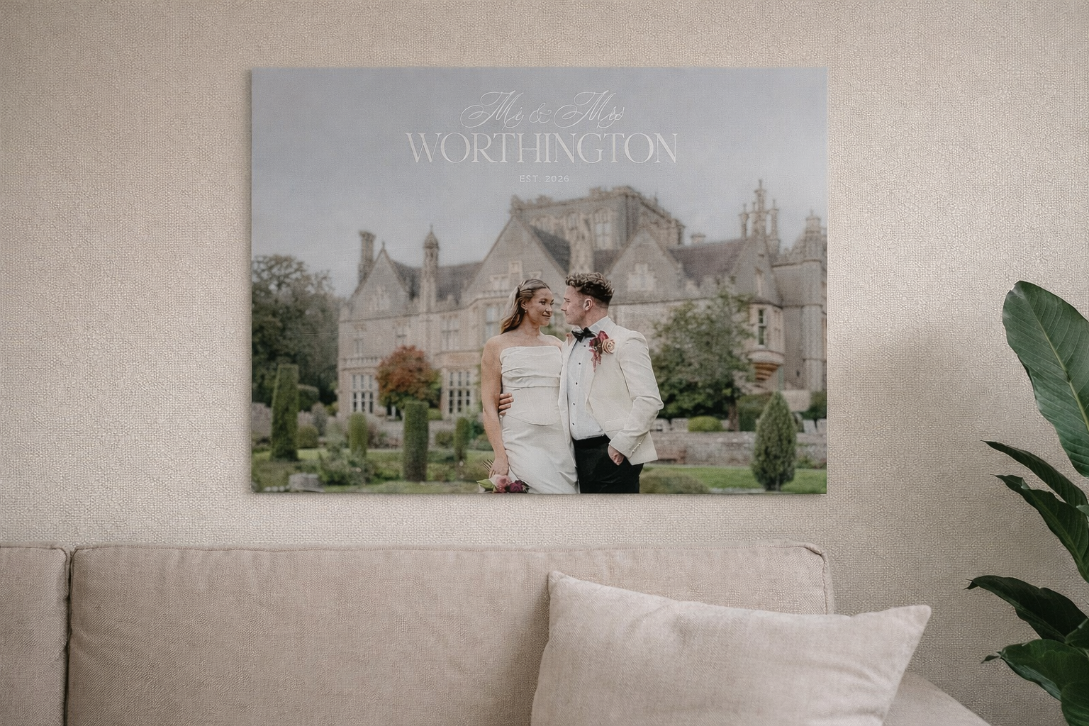 Acrylic print of a couple in front of a large house on a wall above a sofa.