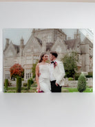 Couple in wedding attire standing in front of a large, elegant building with 'Mr & Mrs Worthington' text, printed onto clear acrylic
