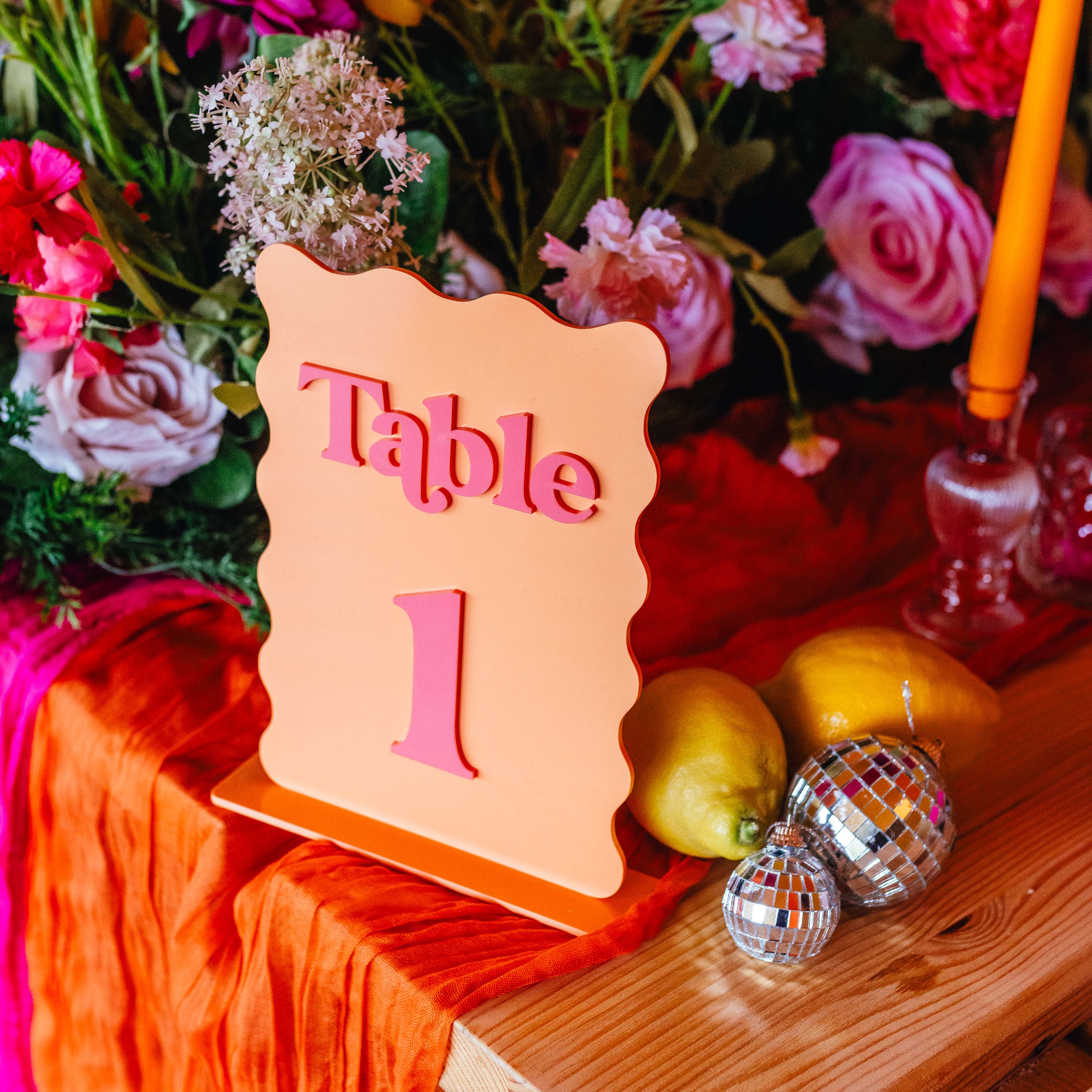 Table number '1' sign on a decorative table with flowers and ornaments.