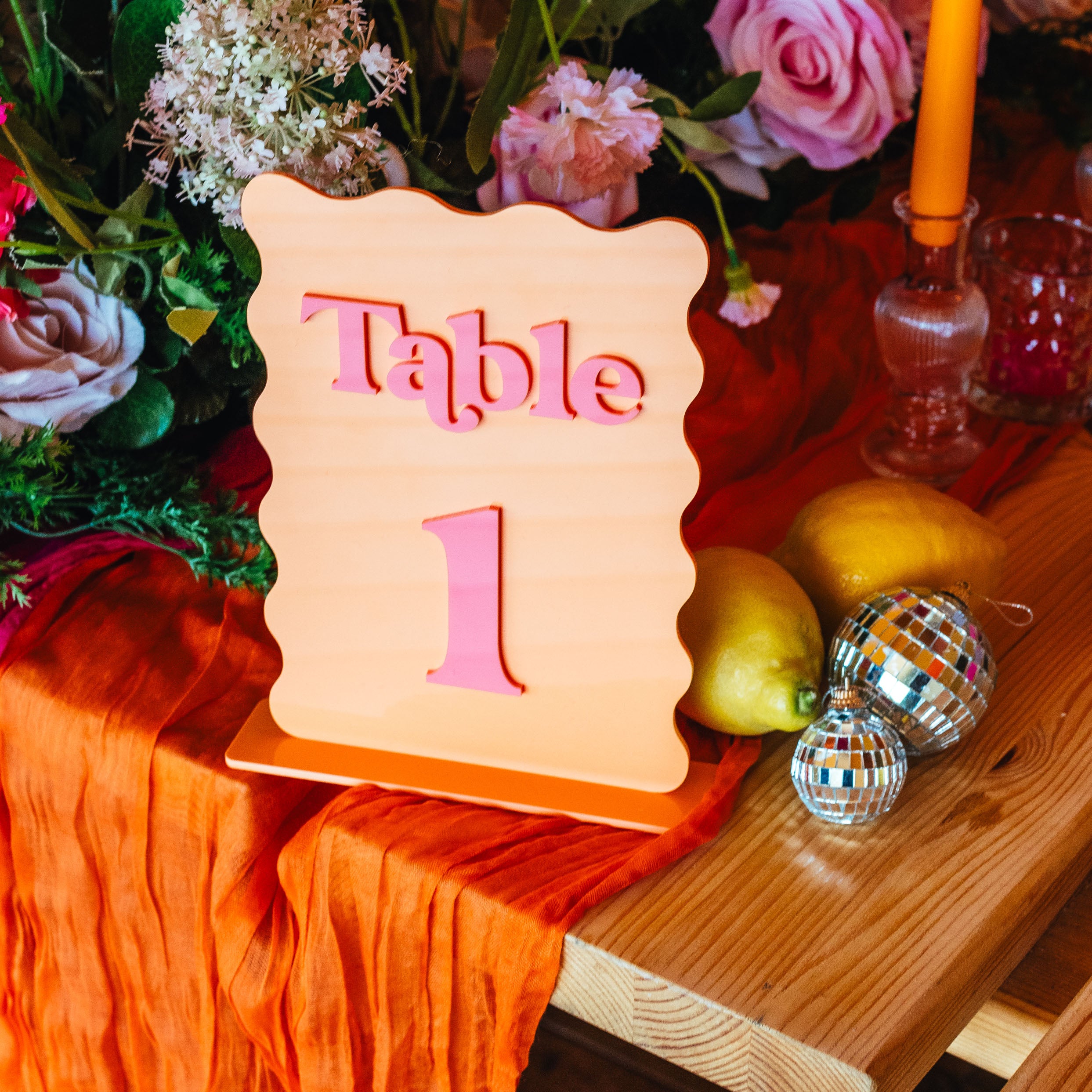 Table number '1' sign on a decorated table with flowers and decorative items.