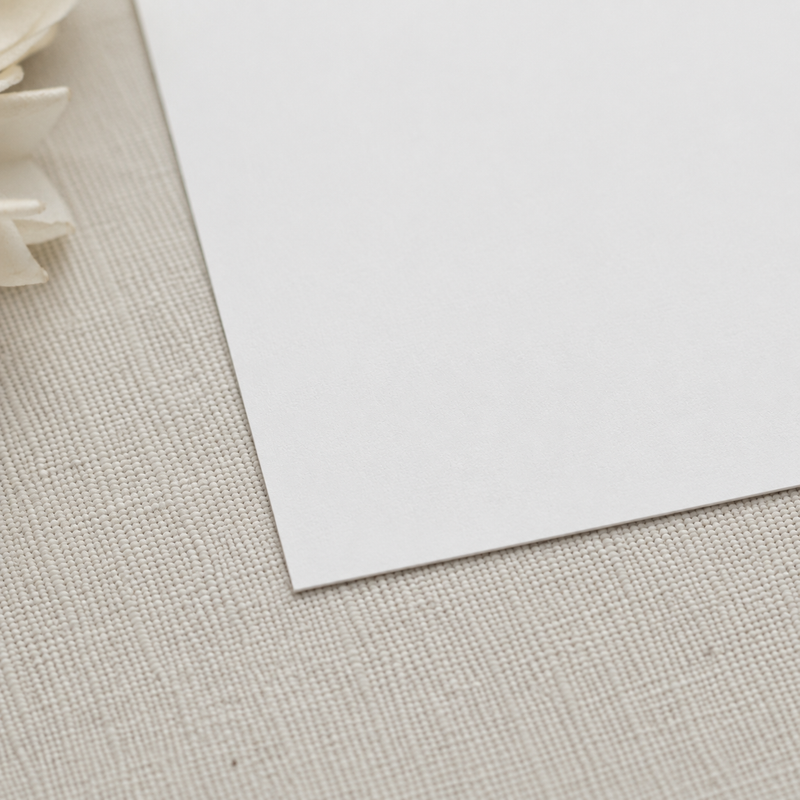 White paper on a textured beige surface