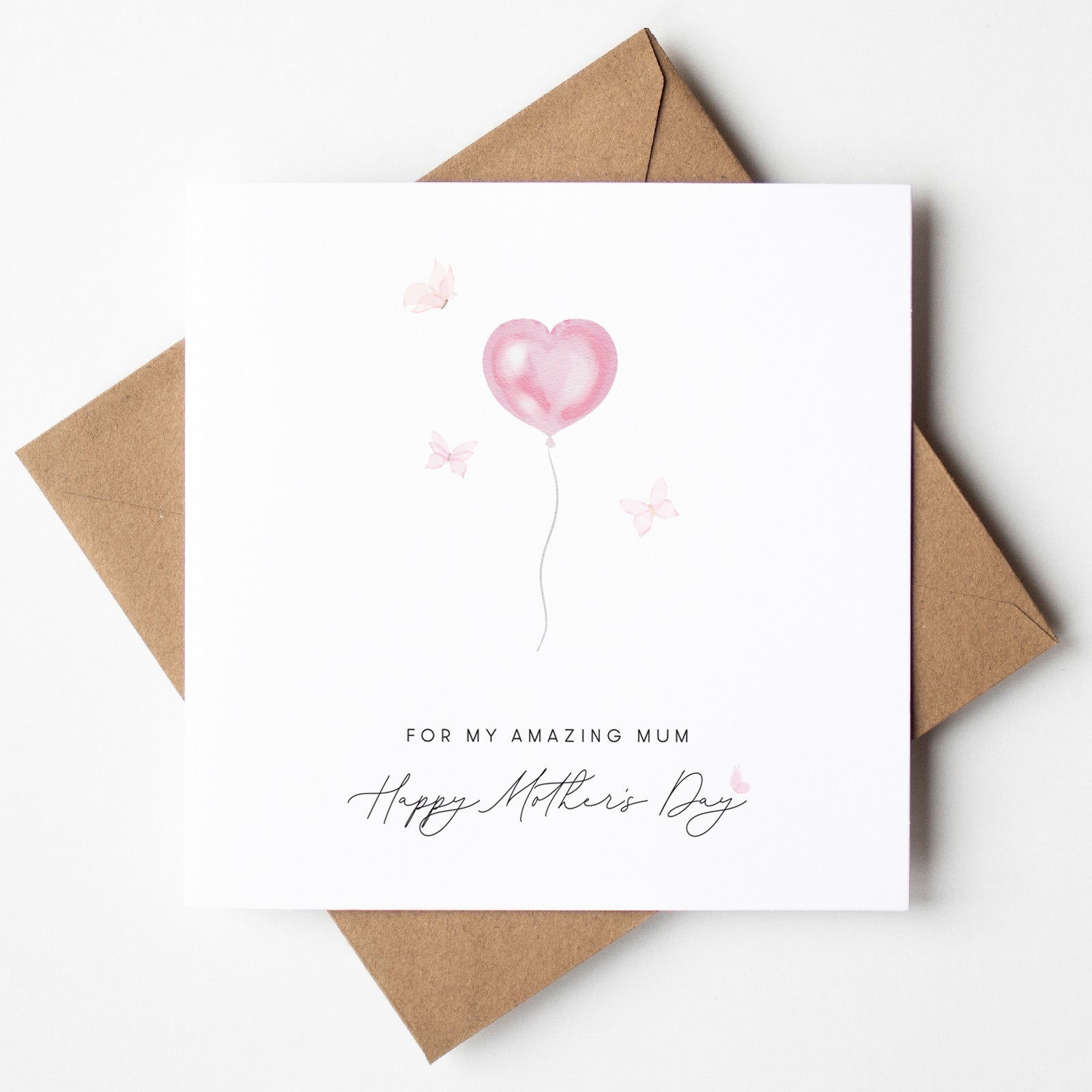 Greeting card with pink heart balloon and 'Happy Mother's Day' text on a white background with brown envelope.