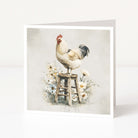 Card with a rooster on a stool surrounded by flowers on a light background