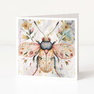 Greeting card with a beetle illustration surrounded by flowers on a white background