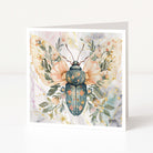 Greeting card with a beetle illustration surrounded by flowers and leaves on a white background