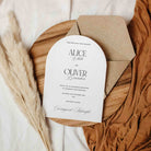 Arched Wedding invitation card with envelope on a wooden board with decorative elements