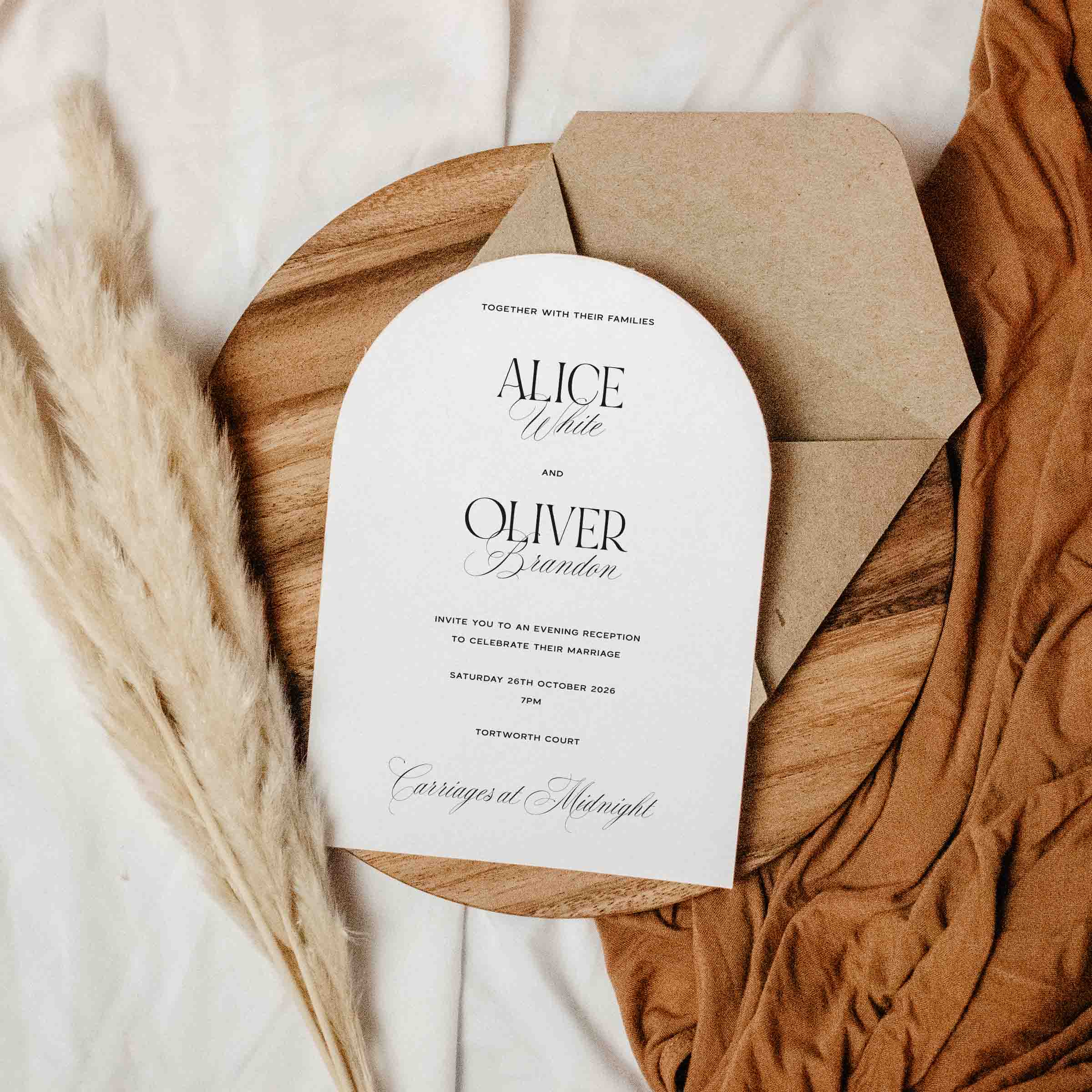 Arched Wedding invitation card with envelope on a wooden board with decorative elements