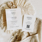 Wedding invitation and RSVP card on a textured surface with decorative elements.