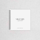 Spiral-bound wedding guest book with 'MR & MRS Brandon' text on a textured gray background