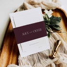 Wedding invitation set with 'Alice and Oliver' on a wooden surface with decorative elements.