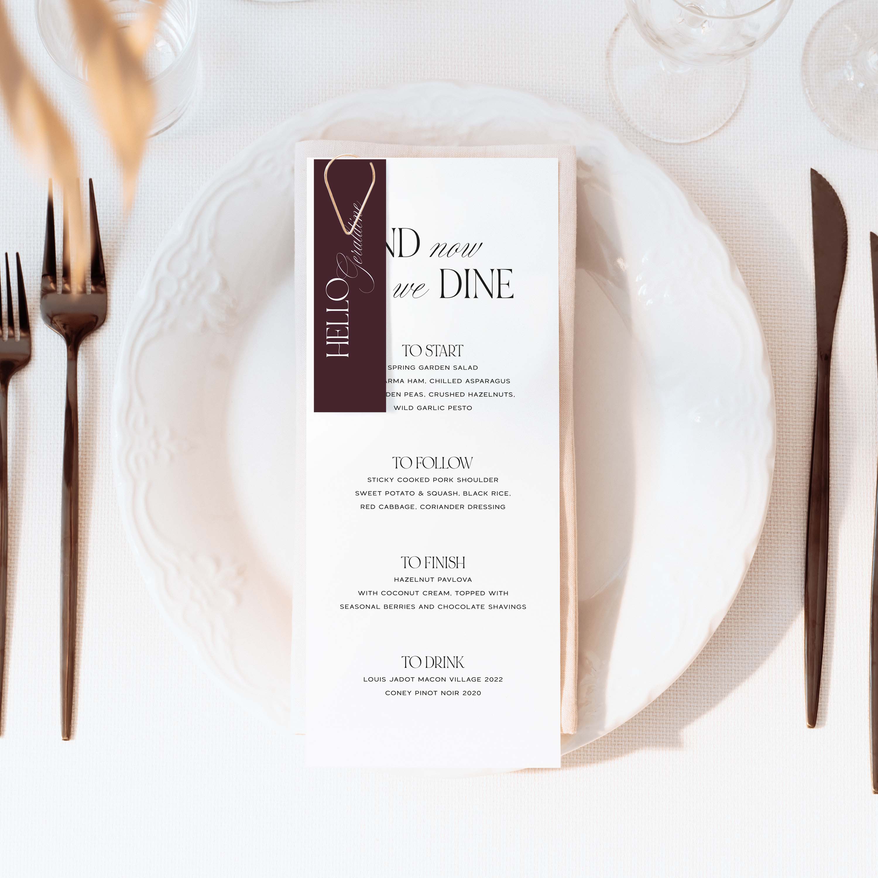 Wedding breakfast menu with guest name tag on a white plate with cutlery