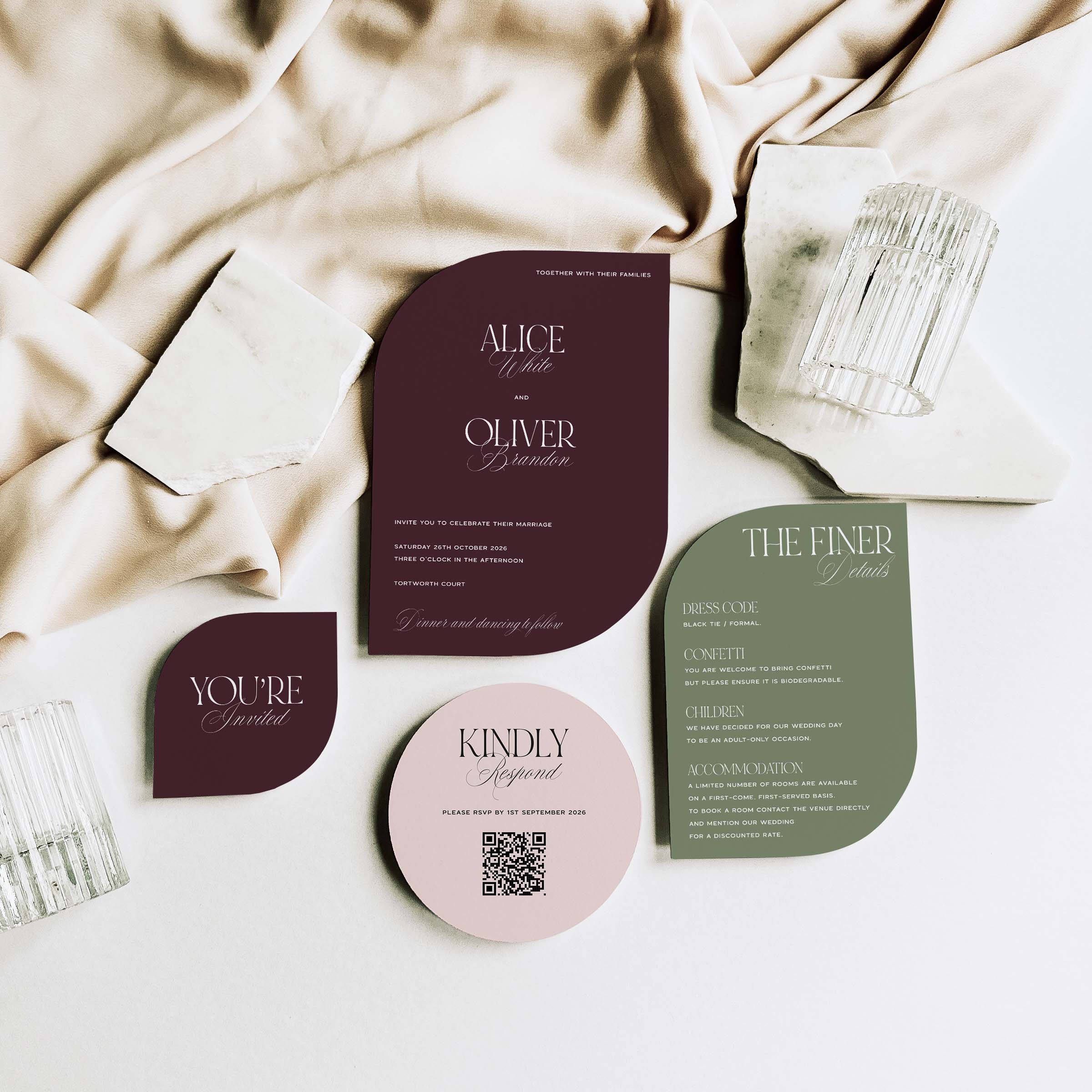 Collection of wedding invitations and cards on a soft fabric background