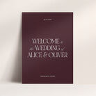 Wedding welcome sign with 'Welcome to the Wedding of Alice & Oliver' on a maroon background