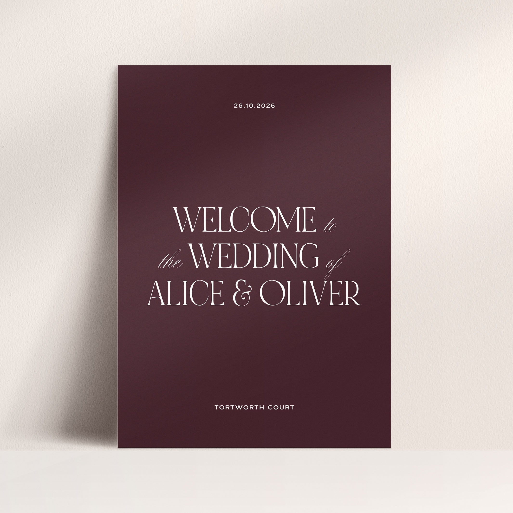 Wedding welcome sign with 'Welcome to the Wedding of Alice & Oliver' on a maroon background