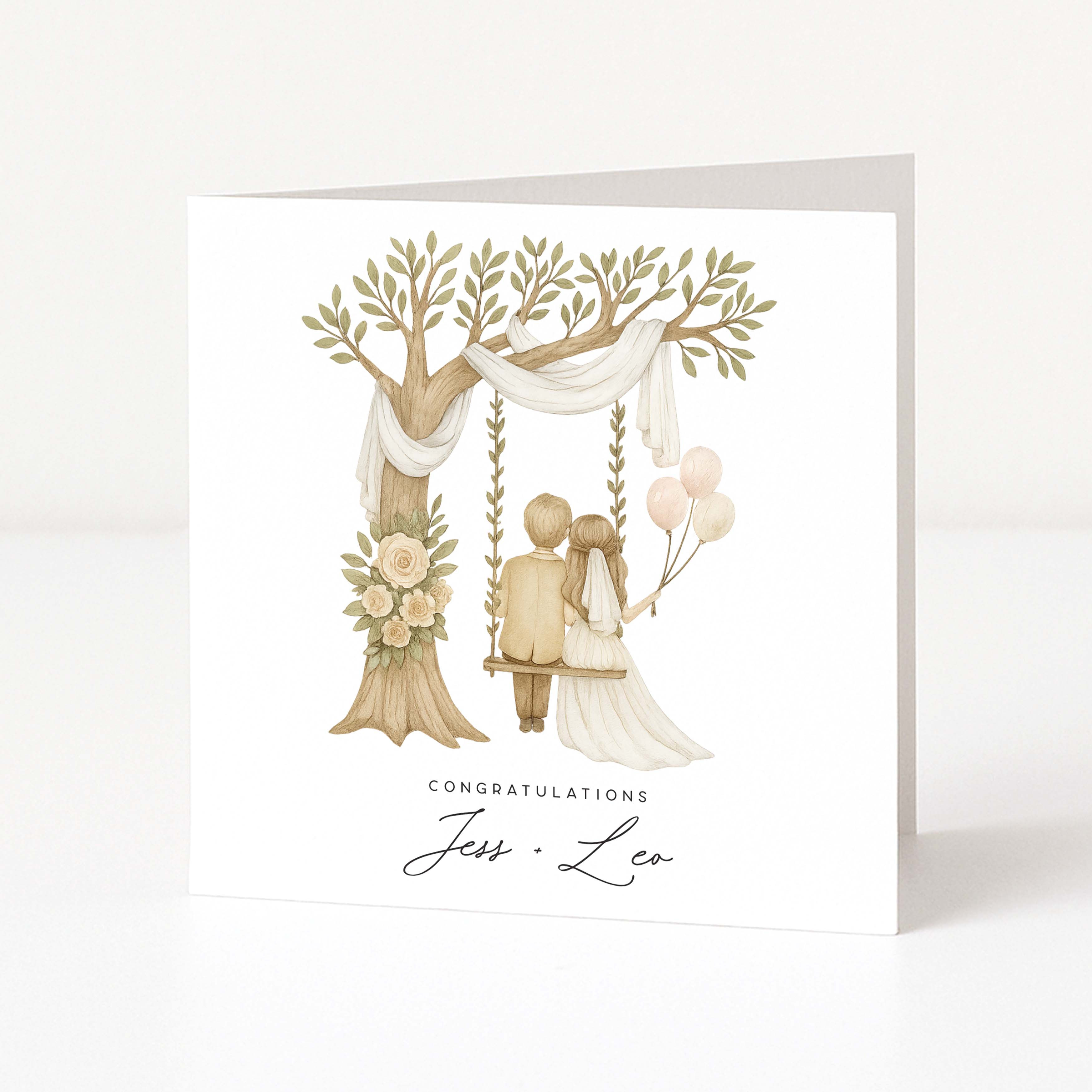Wedding card with a couple on a swing under a tree, surrounded by flowers and balloons.