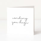 Greeting card with 'sending you hugs' text on a white background