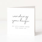 Greeting card with text 'sending you hugs so it's there when you need it' on a white background
