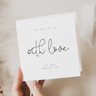 White card with 'To both of you, with love, on your wedding day' text held by a hand.