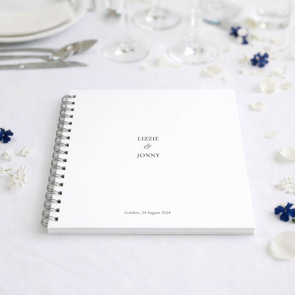Personalised guestbook with names 'Lizzie & Jonny' on a decorative table setting.