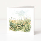 Greeting card with watercolor illustration of a field of flowers on a white background