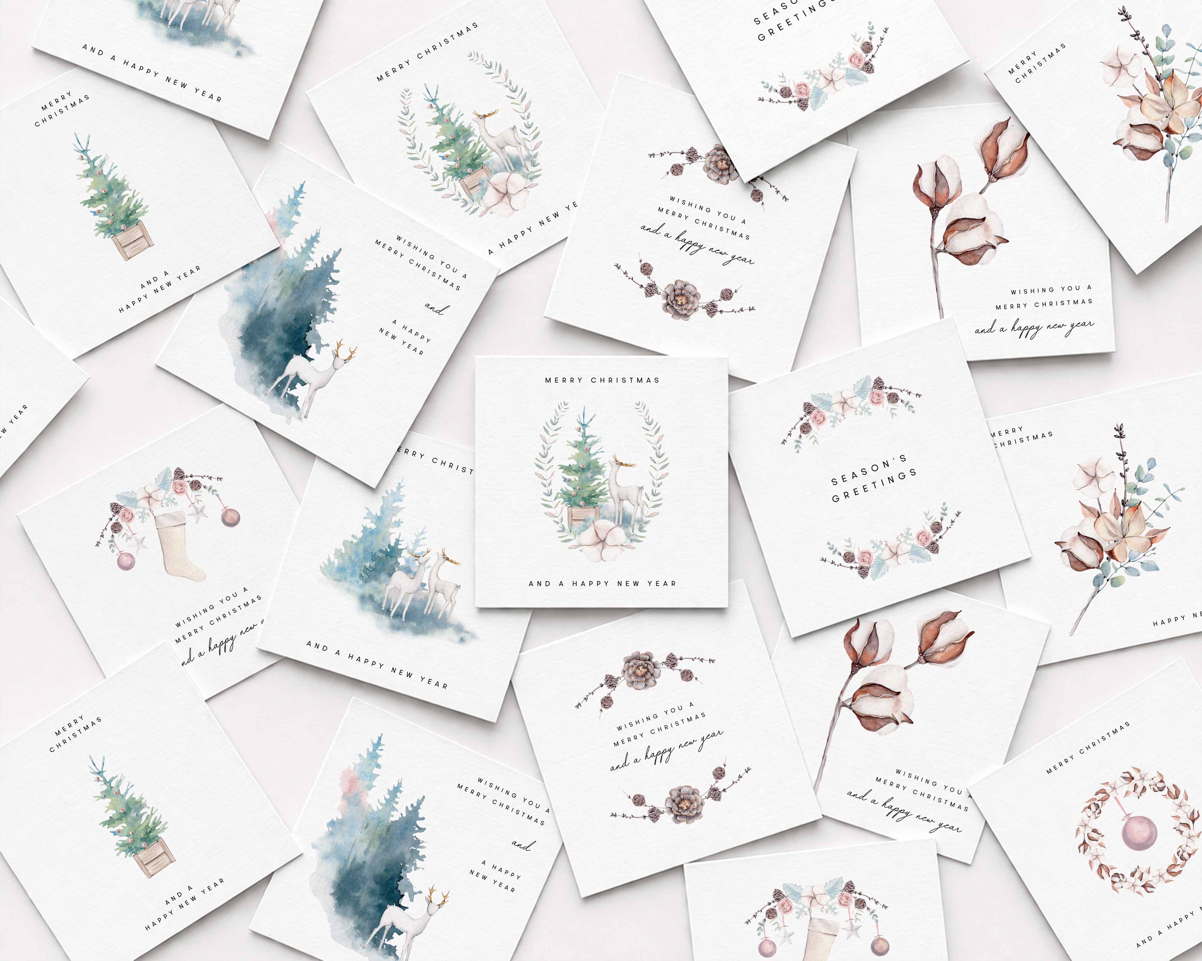 A flat-lay arrangement of multiple white Christmas greeting cards featuring delicate watercolor illustrations of Christmas trees, floral wreaths, pinecones, and holiday motifs on a light background.