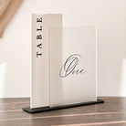 Table number sign with 'TABLE One' on a wooden floor