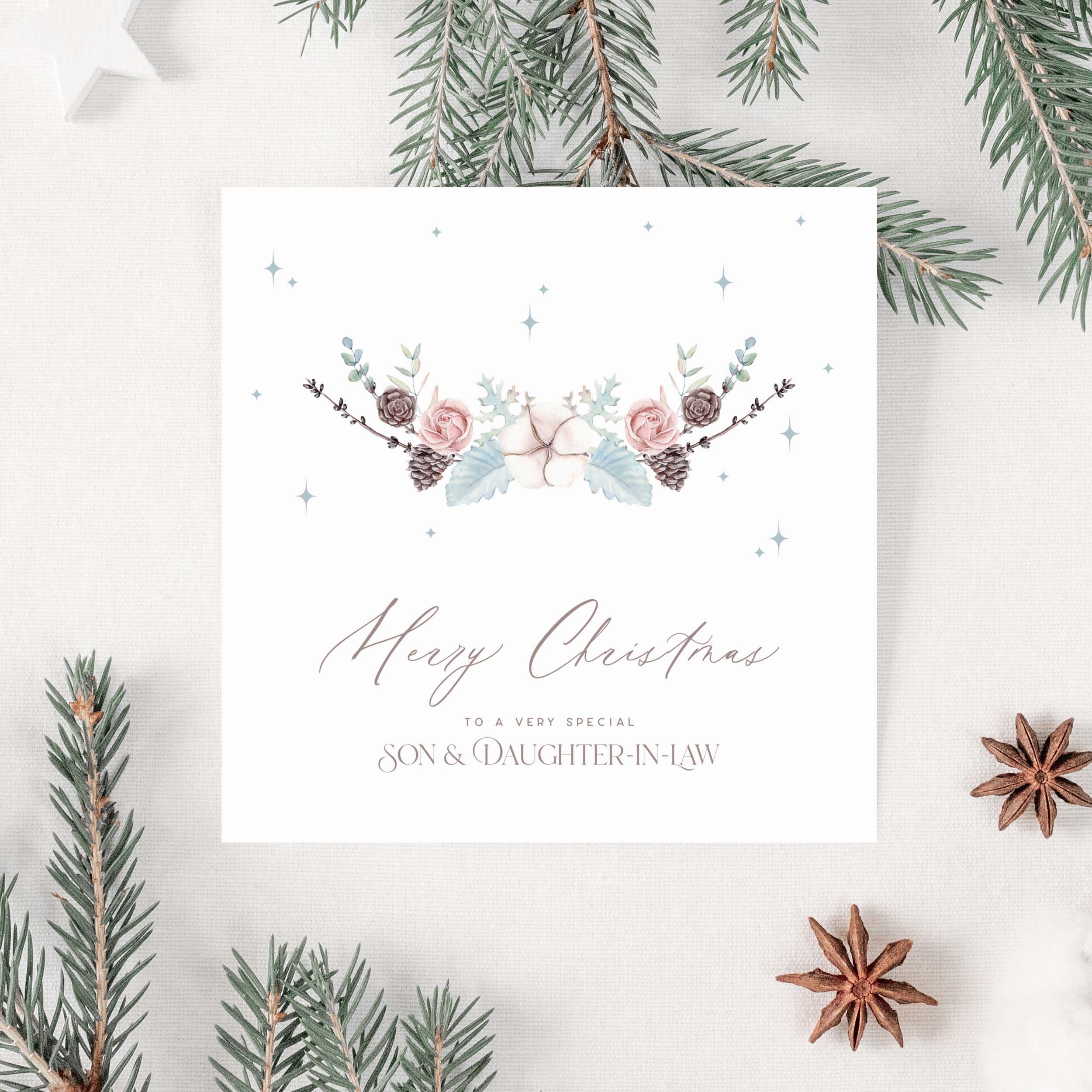Christmas card with floral design and text for a son and daughter-in-law on a white background with Christmas decorations.