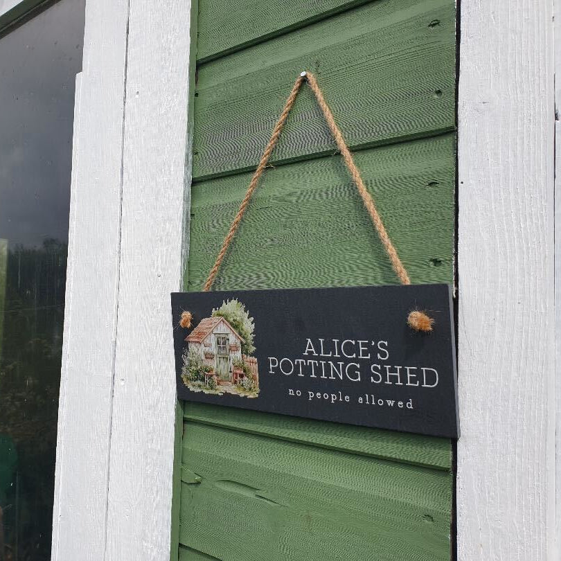 Sign on a potting shed door with 'Alice's Potting Shed' text