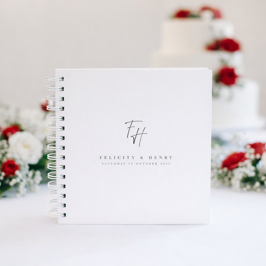 white wedding guest book with white binder with red and white flowers