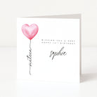Greeting card with pink heart balloon and birthday wishes on a white background